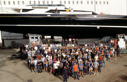  оманда Alloy Yachts International фотографируетс¤ на фоне стро¤щегос¤ судна, 2002 год.